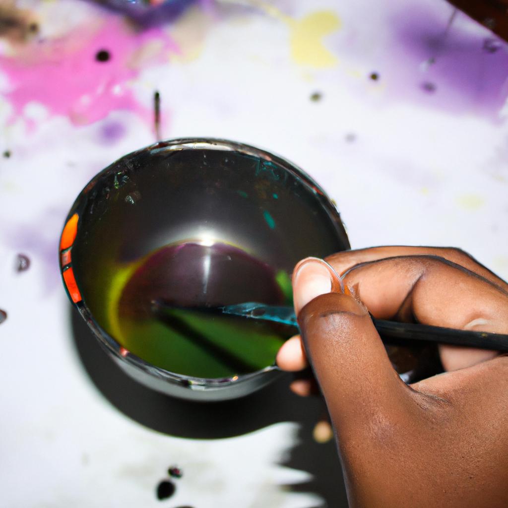 Person holding paintbrush, mixing colors